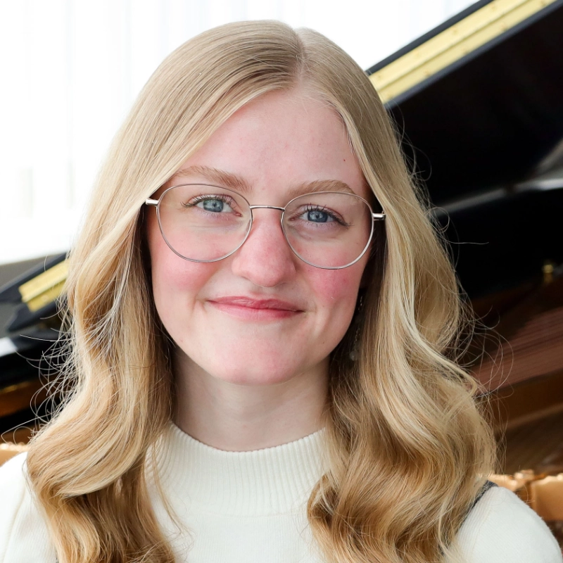 Sophie Comeau sitting in front of a piano